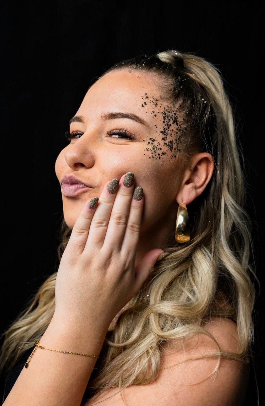 Justine de profil, paillettes sur la tempe et ongles pailletés assortis