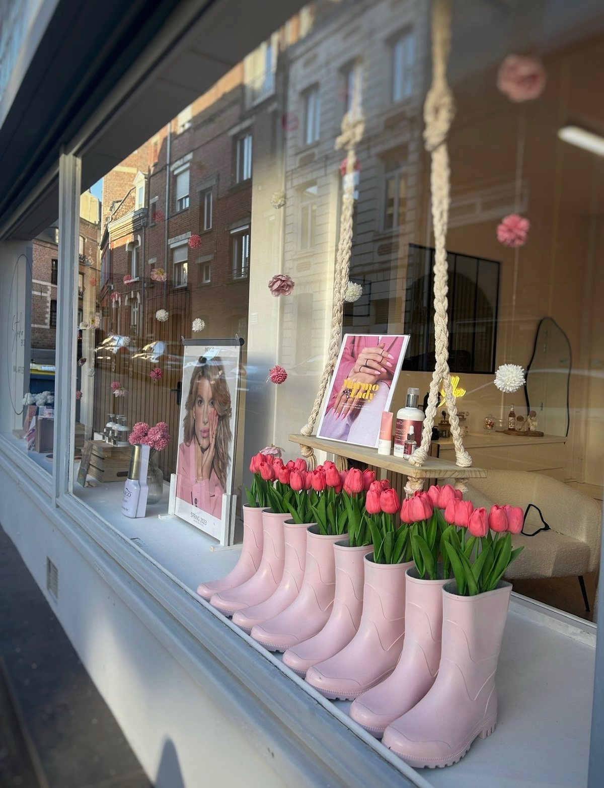La vitrine de printemps : bottes de pluie roses garnies de tulipes