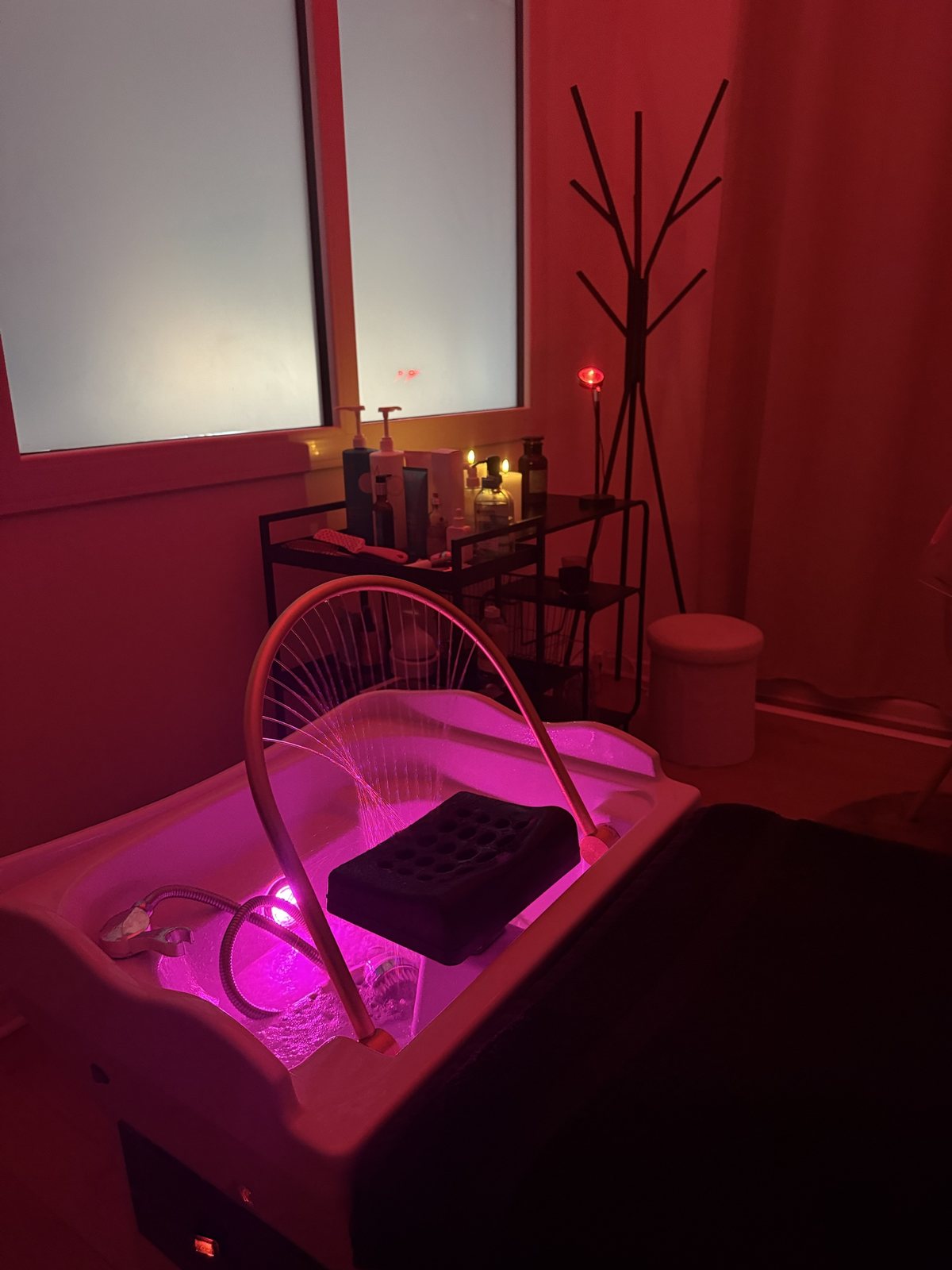 La cabine Head Spa de Studio by Ju à Arras : bac à shampoing éclairé, arceau doré et lumière rose
